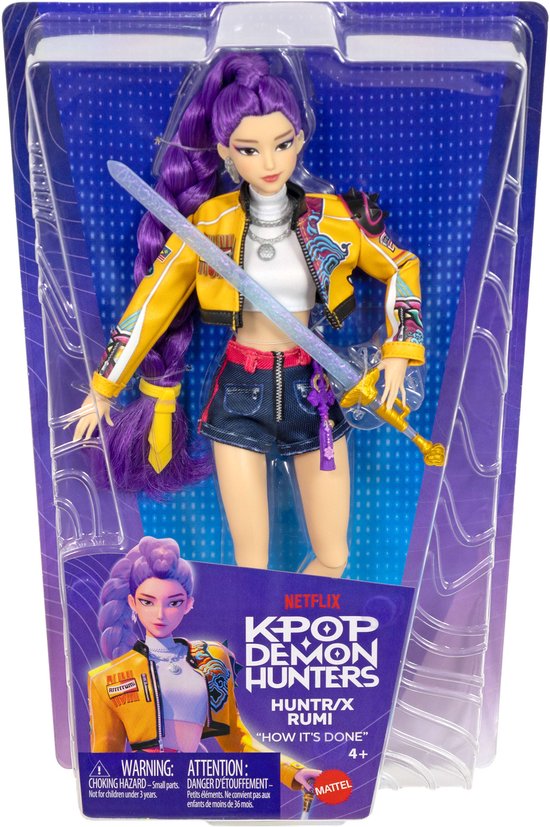 Pop in verpakking: paars haar, gele jas, spijkerbroek shorts, met 'KPOP DEMON HUNTERS' logo.