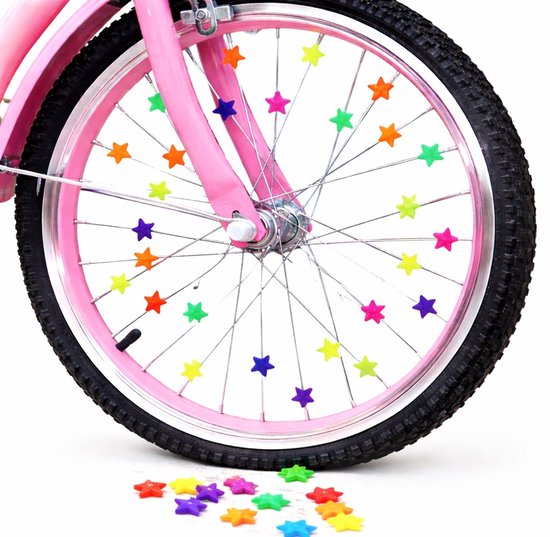 Fietswiel met roze velg en roze frame. De spaken zijn versierd met veelkleurige sterbedels. Sommige sterren liggen op de grond.