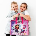 Twee lachende meisjes houden een roze tas vast met Gabby's Poppenhuis personages, waaronder Gabby en haar katten.