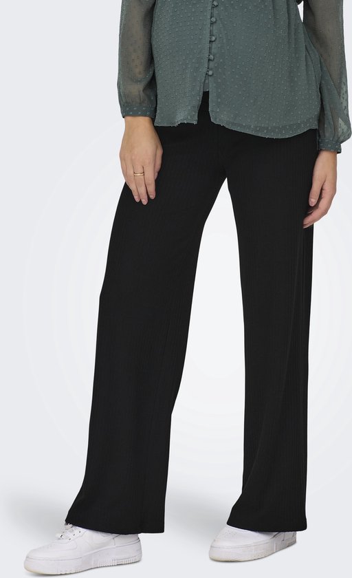 Zwarte wijde ribbroek met een hoge taille, gedragen door een model met een groene blouse.
