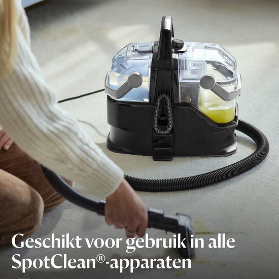 Persoon gebruikt BISSELL reiniger op een tapijt in de woonkamer.