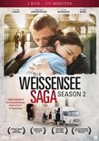DVD-hoes: "Die Weissensee Saga - Season 2", met twee mensen die elkaar omhelzen bovenaan. "WEISSENSEE II is een adembenemend werk."