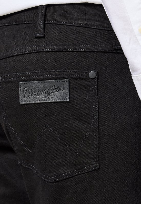 Detail van de achterzak van een zwarte Wrangler jeans met een zwart leren logo.