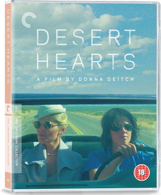 Blu-ray hoesje van Desert Hearts met de voorkant. Twee vrouwen in een cabriolet op een weg onder een blauwe lucht. Filmtitel 'DESERT HEARTS'.