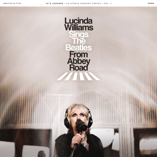Lucinda Williams zingt The Beatles From Abbey Road. Lucinda Williams met koptelefoon en microfoon voor het Abbey Road zebrapad.