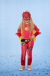 Een meisje met blonde krullen in een roze superheldenpak met gele cape, rode handschoenen, laarsjes en masker. Outfit heeft gele biezen.