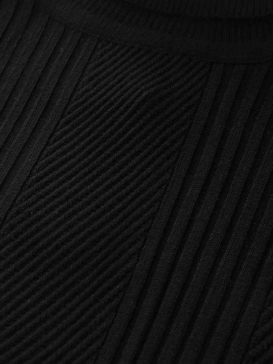 Detail van de zwarte coltrui met ribbelstructuur en een diagonale kabel in het midden.