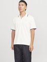 Witte poloshirt met donkerblauwe bies op kraag en mouwen, gedragen door een man met spijkerbroek.