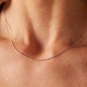 Close-up van een zilverkleurige gourmet schakelketting van 45 cm om de nek van een vrouw.