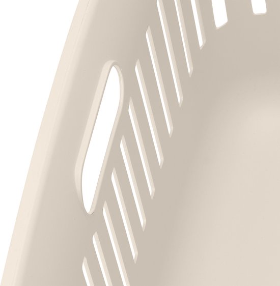 Close-up van de ventilatiegaten en handgreep van een crème wasmand.
