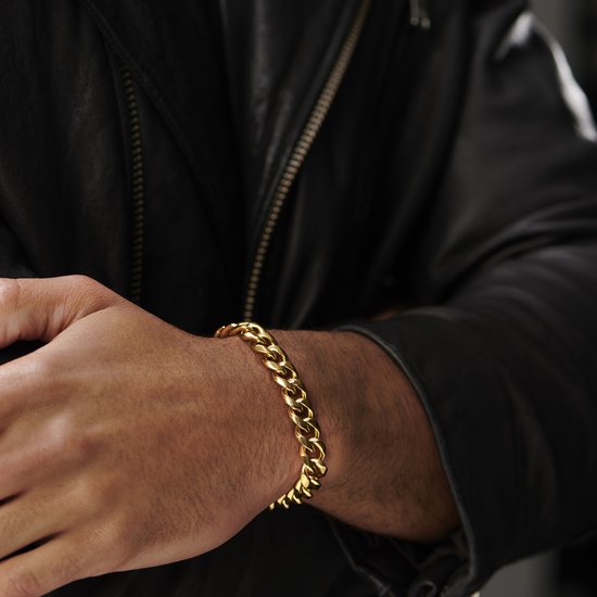 Gouden schakelarmband gedragen door een man om zijn pols, met zwarte leren jas.