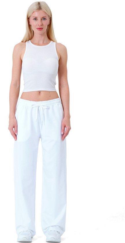 Volledig frontaal aanzicht van een model in witte crop top en witte joggingbroek.