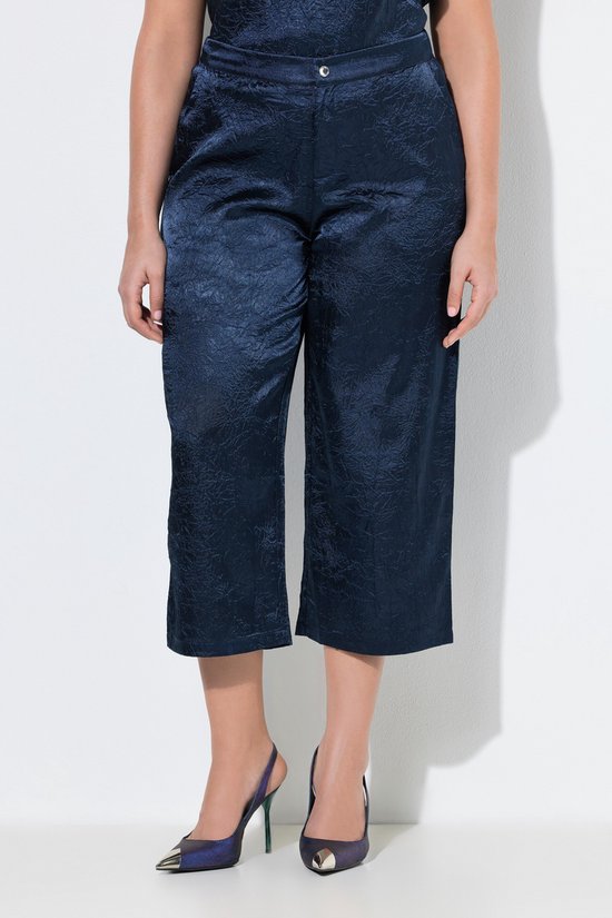 Model in donkerblauwe culotte met textuur, wijde pijpen en comfortabele tailleband.