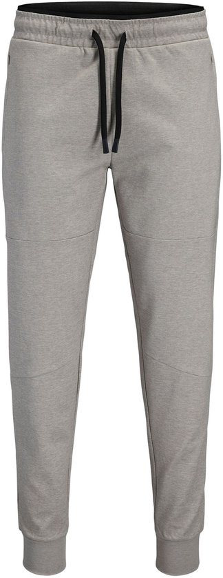 Grijze joggingbroek met zwarte veter en zakken. Strakke enkelbanden. Witte achtergrond.