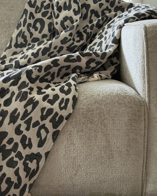 Grijze bank met een beige plaid met zwarte panterprint.