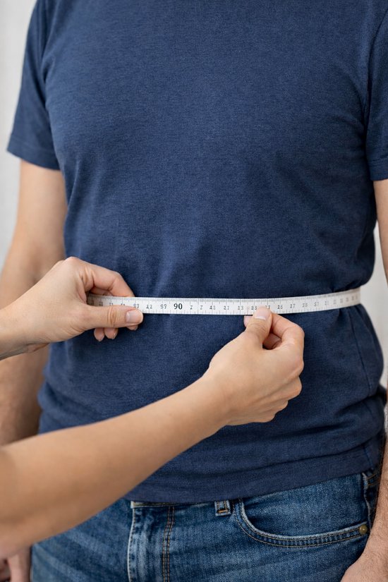 Homme mesuré avec un mètre ruban blanc au niveau de la taille.