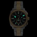 Gouden en zilverkleurig Fossil horloge met zwarte wijzerplaat en lichtgevende uurmarkeringen.