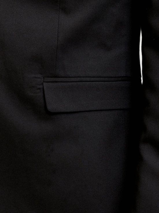 Detail van een zwarte blazer met klepzak.