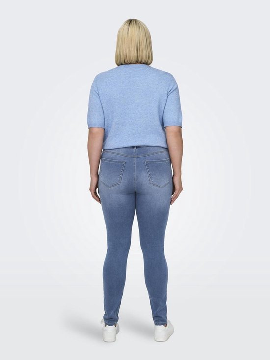 Model met blonde bob draagt blauwe spijkerbroek en lichtblauwe top.