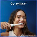 Vrolijke vrouw met bruine ogen poetst haar witte tanden met een witte Oral-B elektrische tandenborstel met groene accenten.