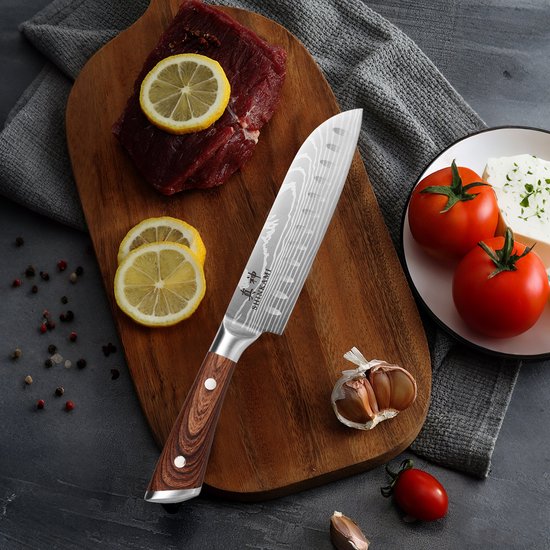 Couteau de cuisine japonais Damas, manche en bois, à côté de viande crue, citron et tomate.