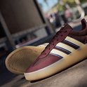Bordeauxrode sneaker met beige en blauwe strepen, beige zool.