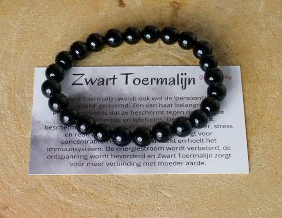 Bracelet en tourmaline noire avec des perles noires et des reflets blancs. Carte avec 'Zwart Toermalijn'.