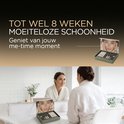 Jonge vrouw kijkt in de spiegel met een KYRO Beauty Lash Lift Kit, glimlacht.