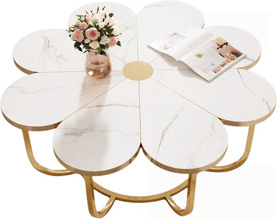 Bloemvormige salontafel met wit marmeren blad, gouden accenten, vaas met roze bloemen en open boek.