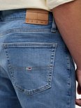 Detail van de achterzak van een blauwe jeans met lichte wassing.