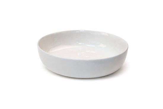 Een enkele witte kom met afgeronde zijkanten, op een witte achtergrond.
