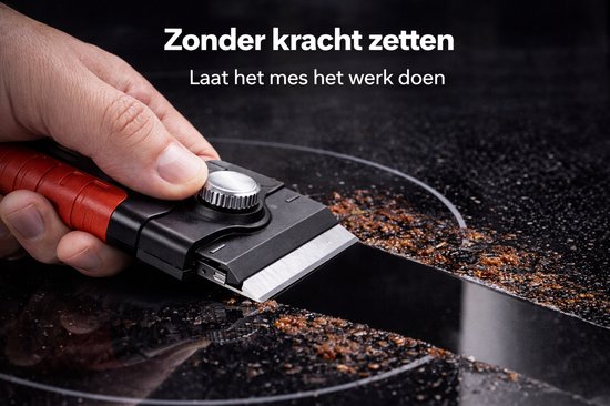 Hand met rode greep gebruikt schraper om aangekoekte etensresten van zwarte inductiekookplaat te verwijderen.