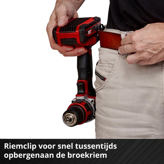 Een man gebruikt een rode en zwarte Einhell accuboormachine in een werkplaats. De boormachine is vastgeklikt aan zijn riem.