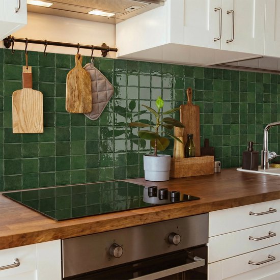 Een woonkamer met een open haard versierd met mosgroene, glanzende 3D-wandtegels.