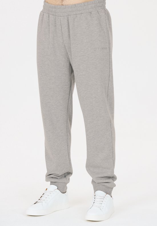 Man draagt een grijze casual joggingbroek met VIRTUS logo.