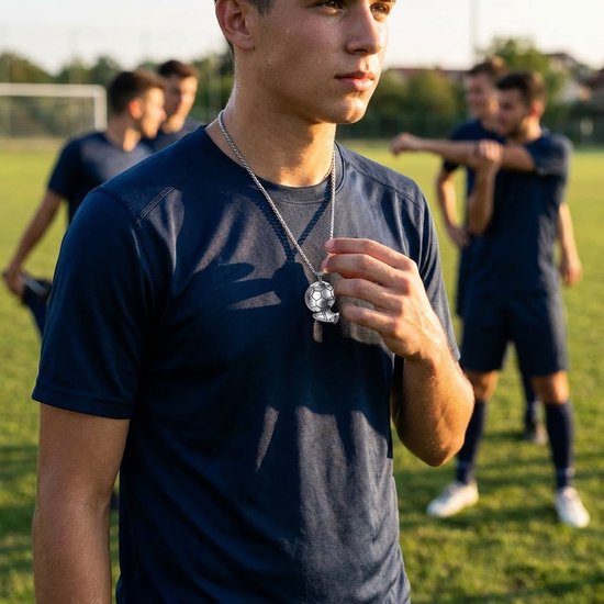 Jonge man met een donkerblauw sportshirt draagt een zilverkleurige voetbal- en schoenhanger aan een schakelketting.
