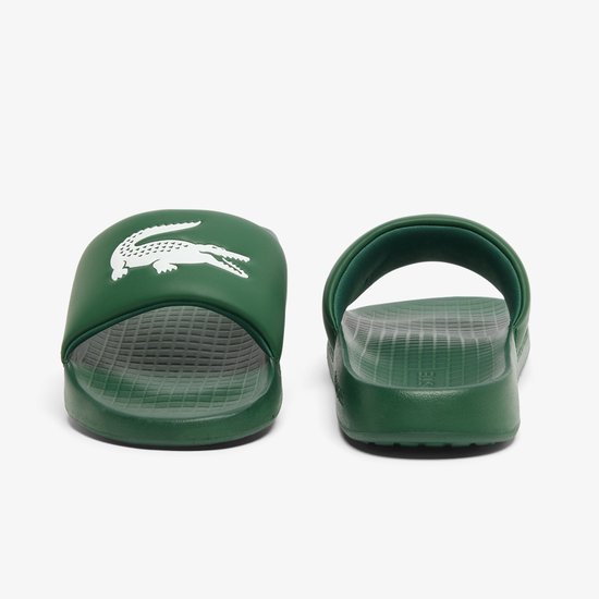 Donkergroene Lacoste slippers, voorkant met wit krokodil logo, zijkant met Lacoste tekst.