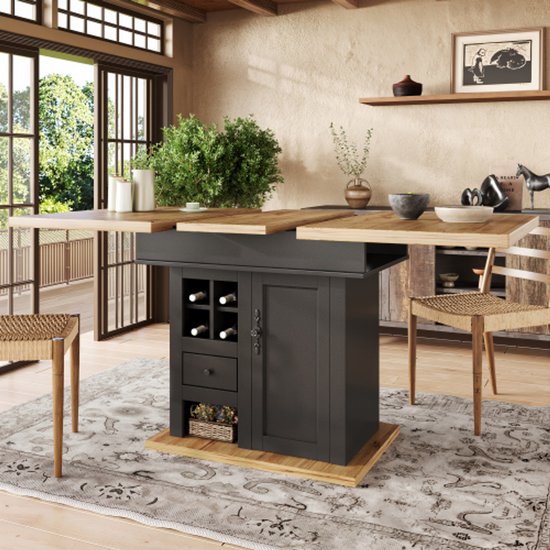 Donkergrijze eettafel met houten blad, met een middenconsole met wijnrek en lade. Houten stoelen met gevlochten zittingen.