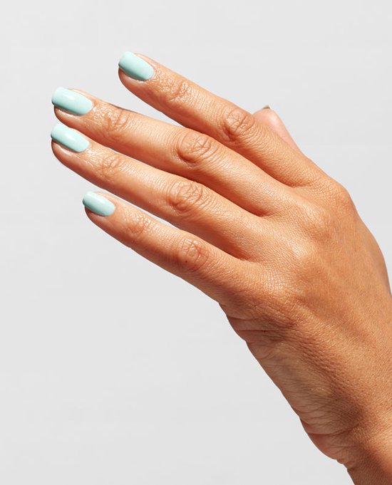 Een hand met mintgroene, glanzende nagels op een lichte achtergrond.