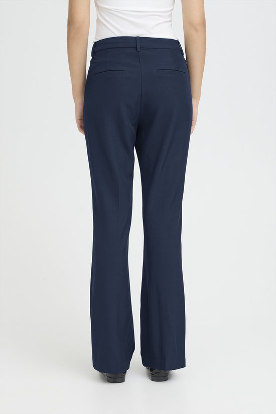 Donkerblauwe broek met wijde pijpen, gedragen door een model van achteren gezien.