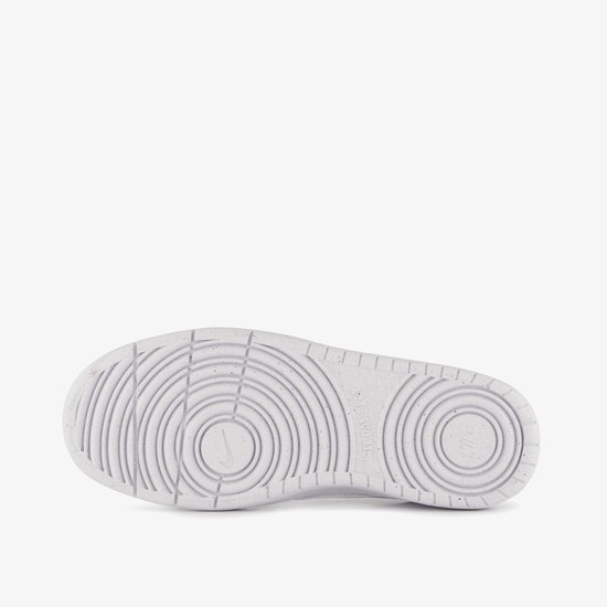 Onderkant van een witte Nike sneaker met een cirkelvormig profiel en gespikkelde rand.