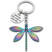 Zilverkleurige libelle sleutelhanger met veelkleurige vleugels en 'She believed she could so she did' tekstbedel.