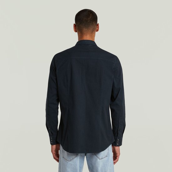 Achterkant van een donkerblauw G-Star overhemd, gedragen door een man.