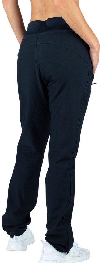 Achterkant van een vrouw in zwarte trainingsbroek met trekkoord, ritsen aan de enkel en witte biezen.