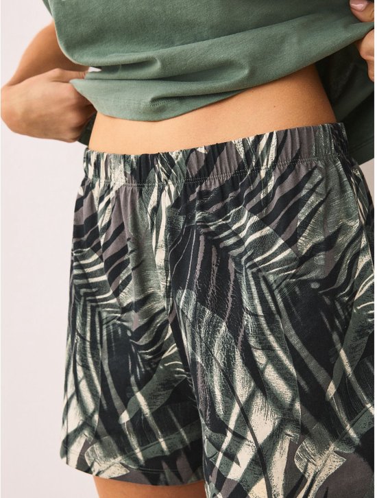 Close-up van de tailleband van een short met bladerenprint.