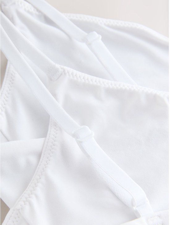 Sluiting van witte bralette met haakjes en oogjes.