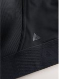 Close-up van zwart sportbeha-detail met driehoekig logo en gestructureerde onderband.