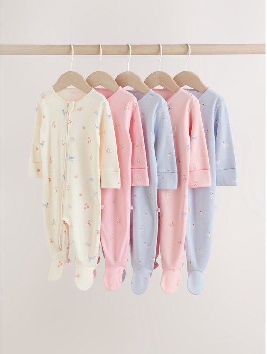 Vijf babypyjama's in pastelkleuren, hangend aan een rek, met dierenprints.