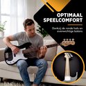 Man speelt ontspannen op een zwarte basgitaar met een witte slagplaat op een bank.