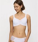 Model draagt een witte Triumph beha met kanten details en een bijpassende slip.